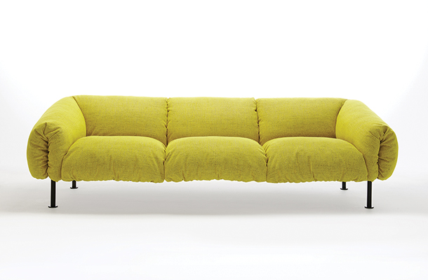 Mustard yellow, soft-cushioned, three-seater sofa with fabric cover